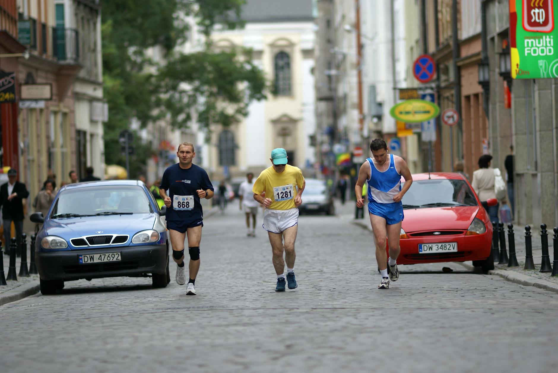 Ilustracja przedstawiająca połączone motywy sportowe: boisko piłkarskie i drogę kolarską, symbolizujące sportowe wydarzenia w Radomiu.